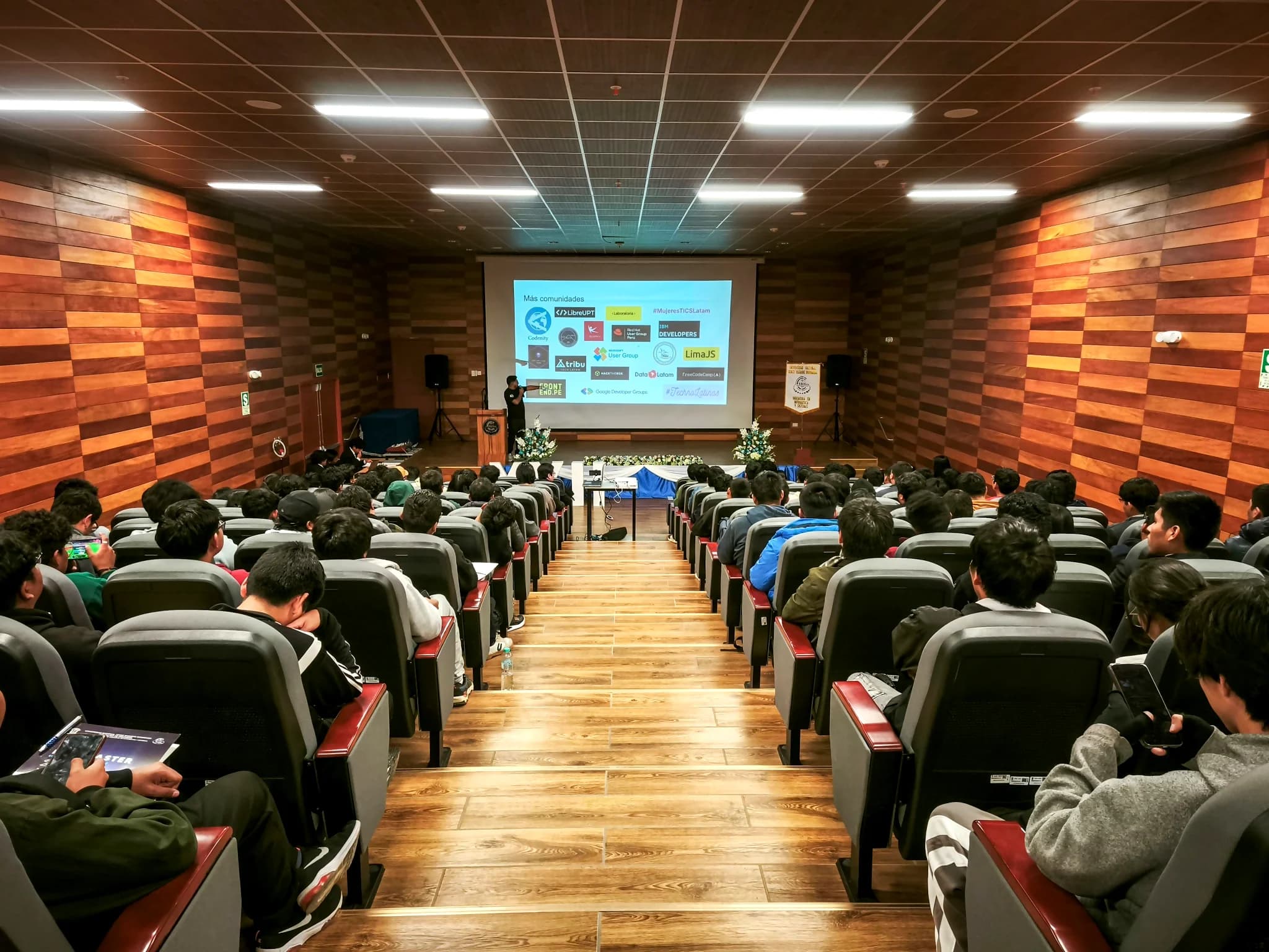 Full auditorium during a talk, seen from the back rows